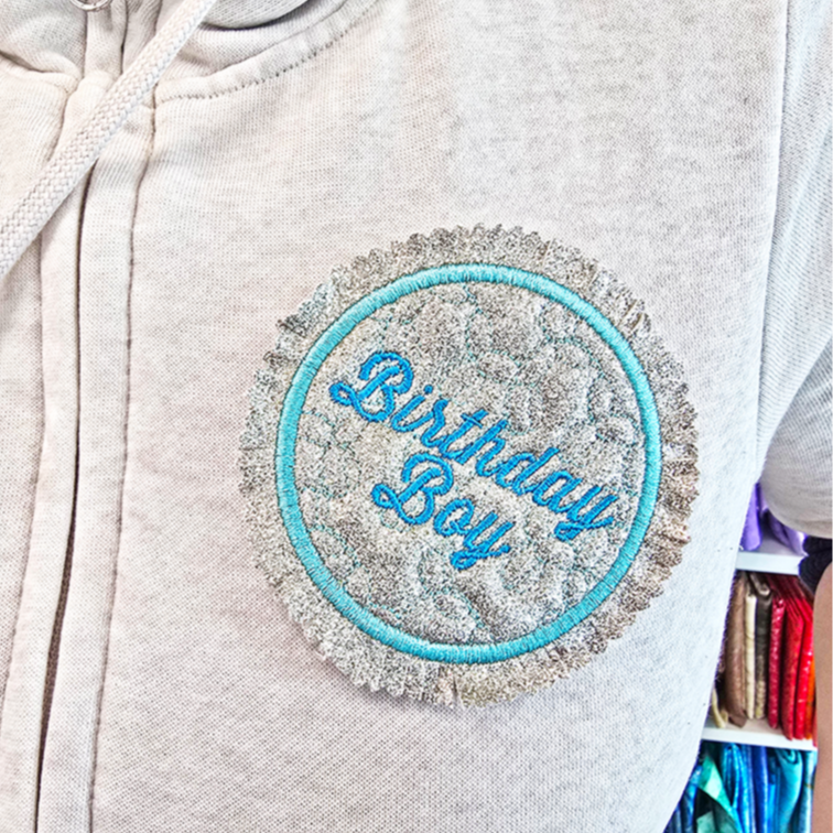 Light gray hoodie with ITH 'Birthday Boy' patch worn