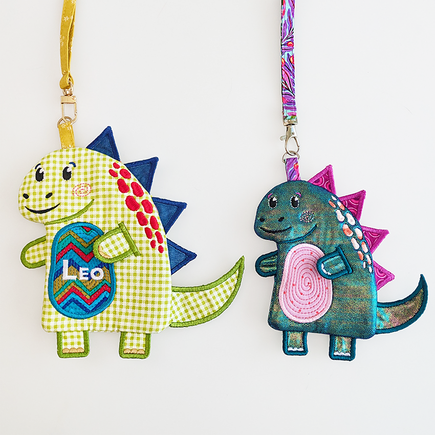 Two dinosaur-shaped zipper purses made ITH
