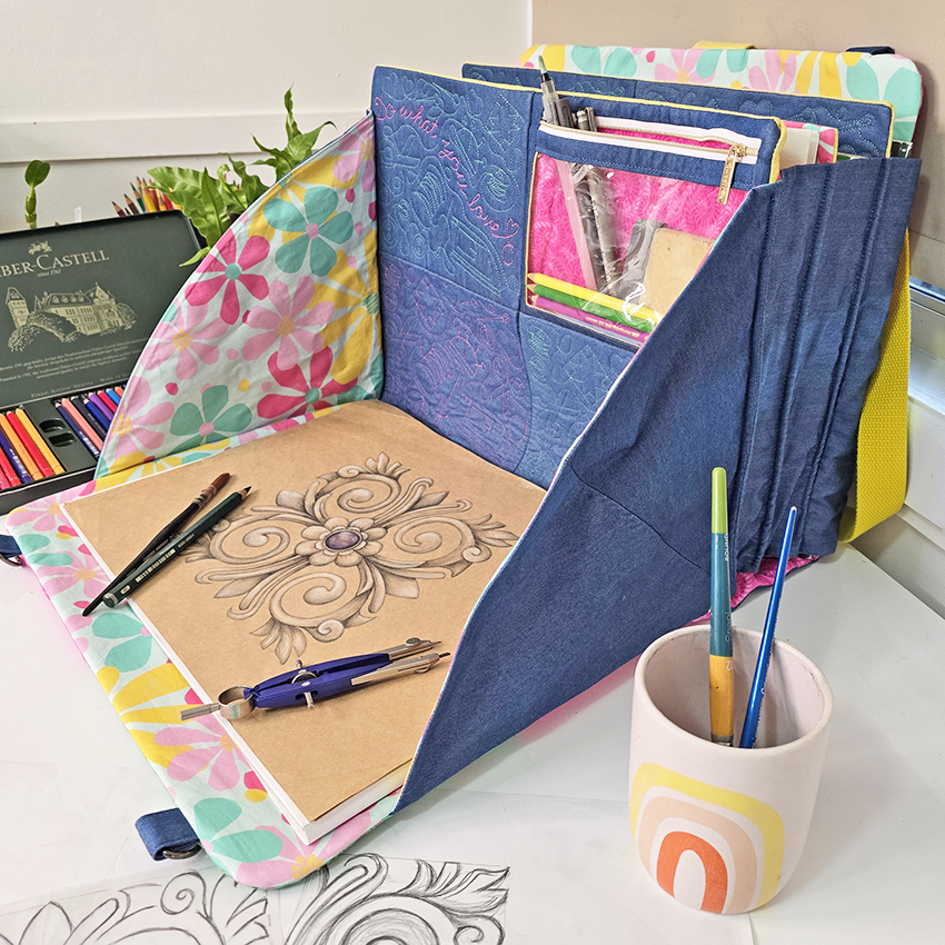 Craft tote with stationery items including notebooks, pens, and a cup on a desk