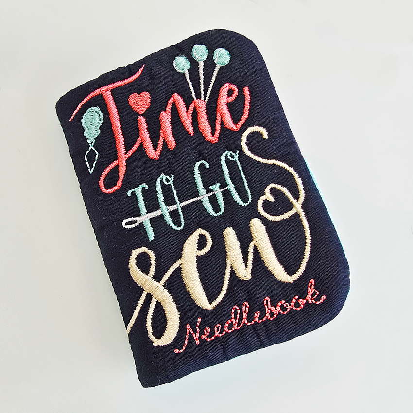 Embroidered needle book with colorful text on a white background by sweet pea