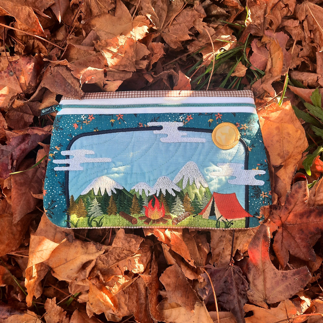 Embroidered pouch with nature design on a bed of autumn leaves