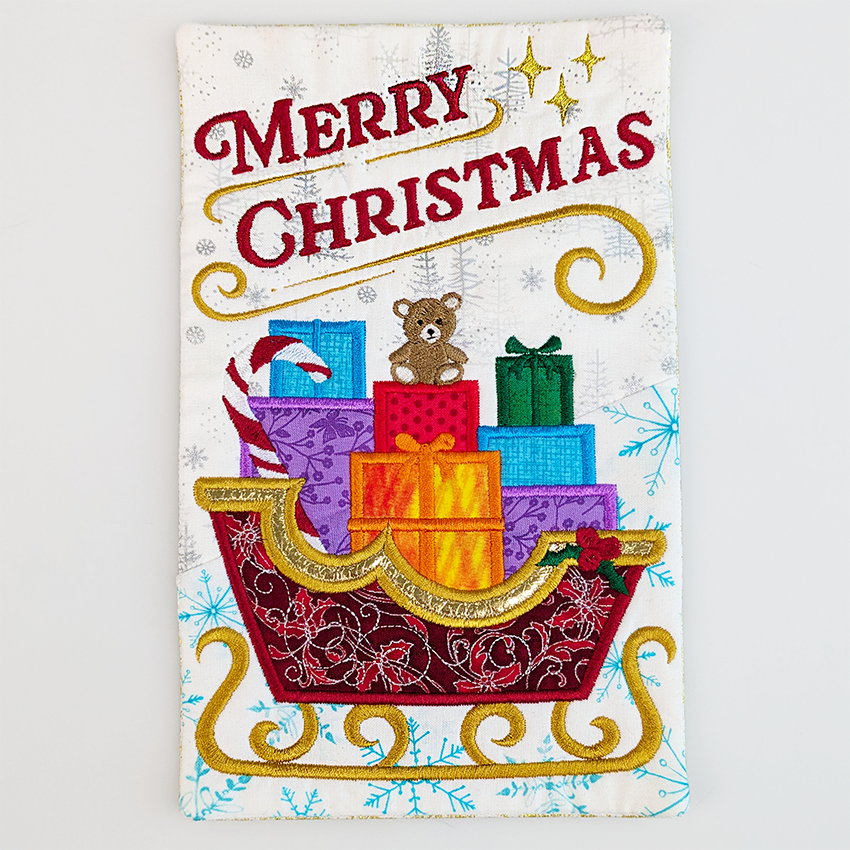 Christmas-themed coaster with a sleigh full of gifts and a teddy bear