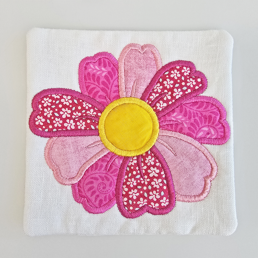 Embroidered sweet pea flower with a yellow center