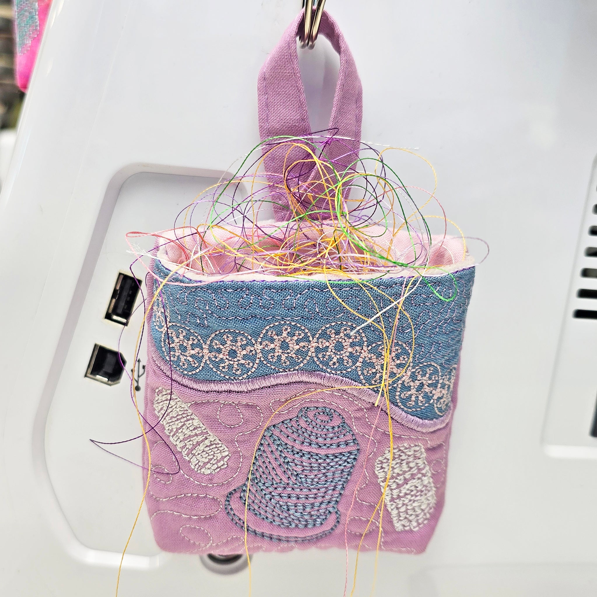 small thread catcher holding thread and hanging on machine