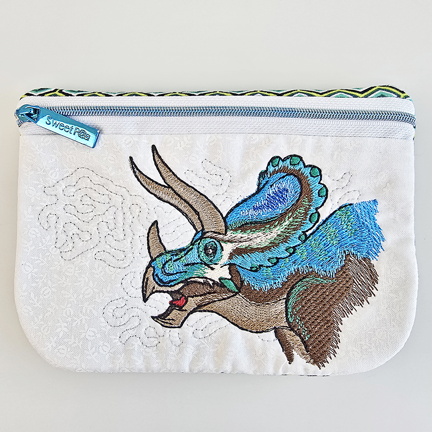Embroidered triceratops design in blue, smaller size