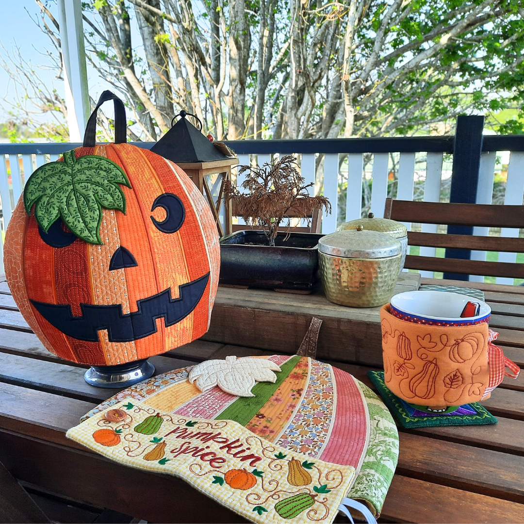 Decorative pumpkin teapot cosy, drink cosy, and coaster in an afternoon setting