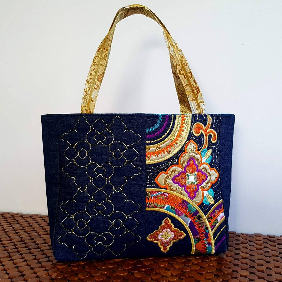 Colorful japanese inspired embroidered bag on a wooden surface with a white background