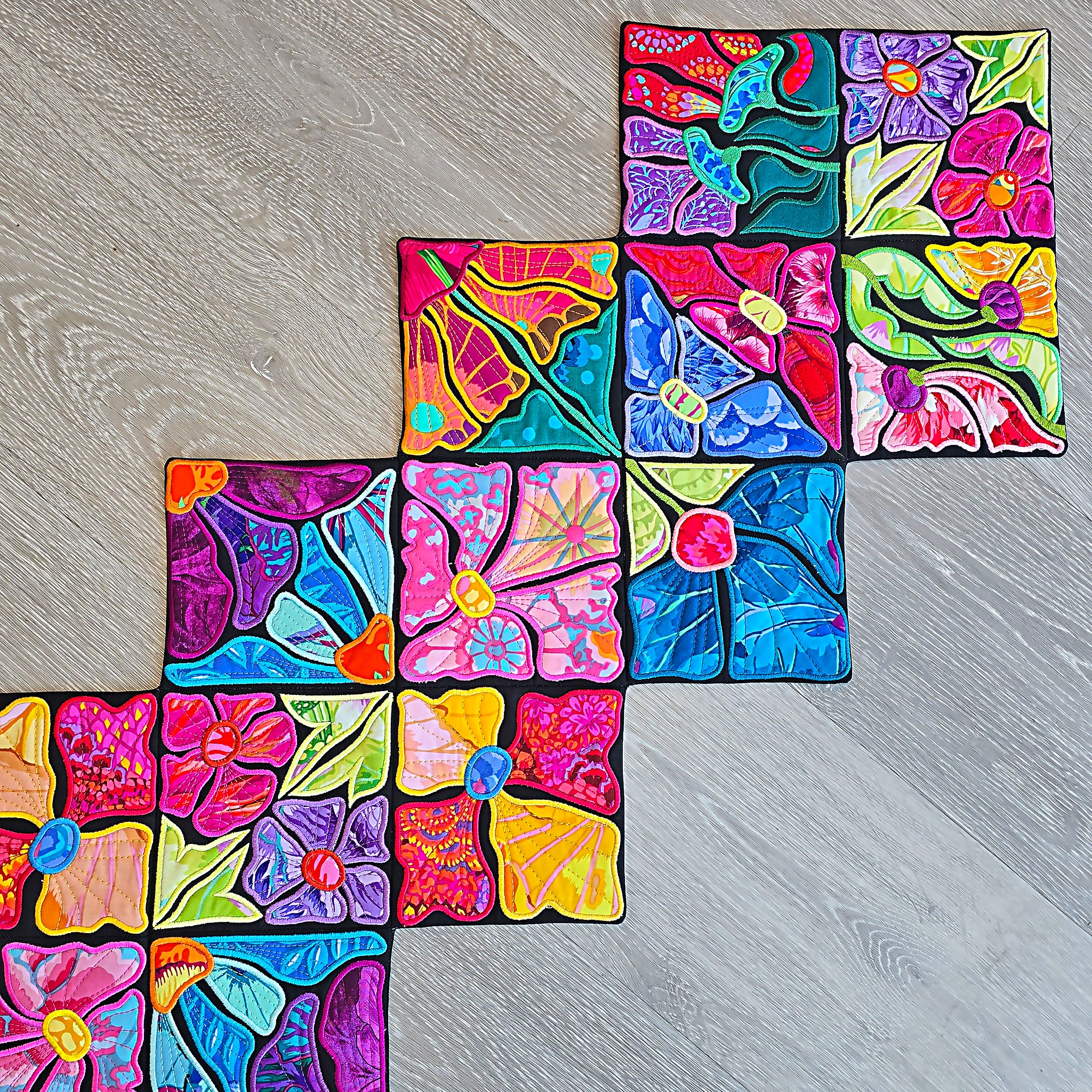 Colorful floral ITH table runner on a wooden surface