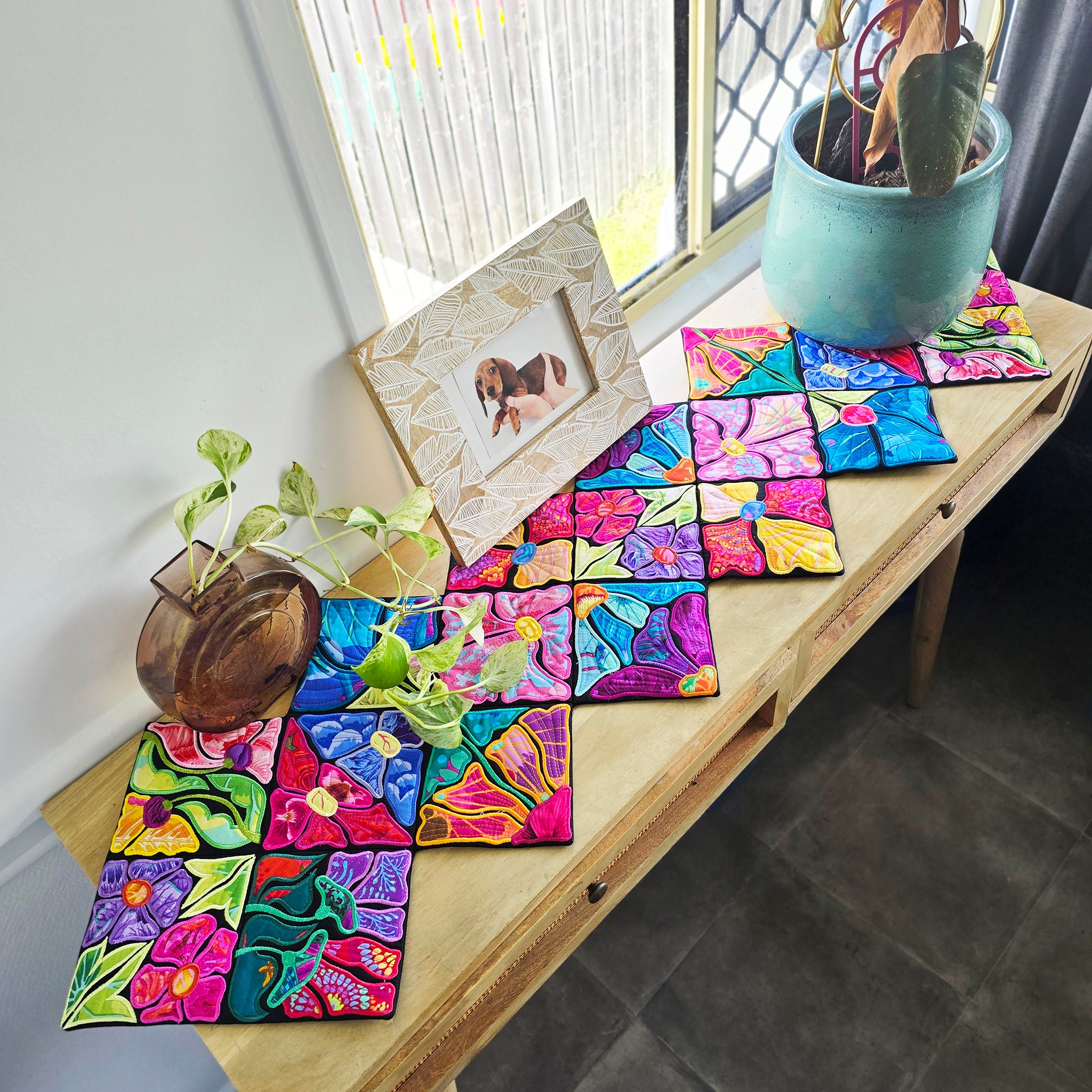 Colorful ITH floral runner on a wooden side table. 