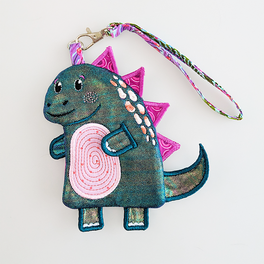 shiny dinosaur purse with pink spikes and wrist strap in smaller size