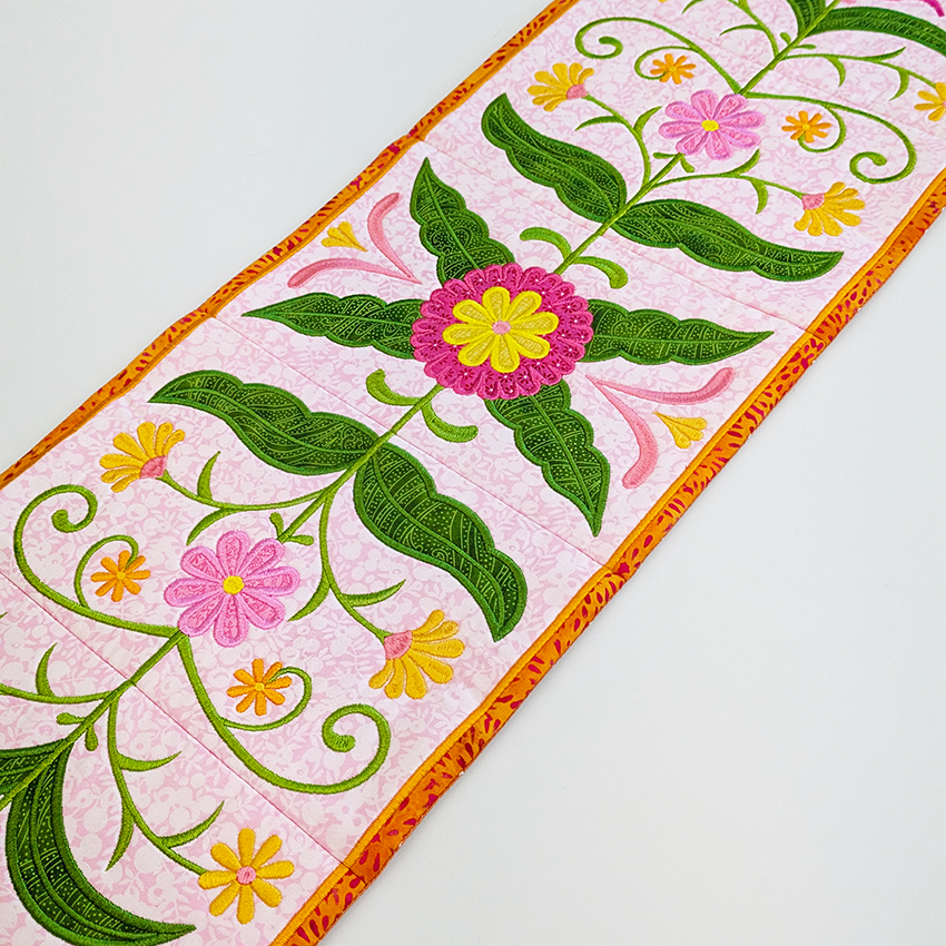 Floral ITH design with pink flowers and green leaves on a white background