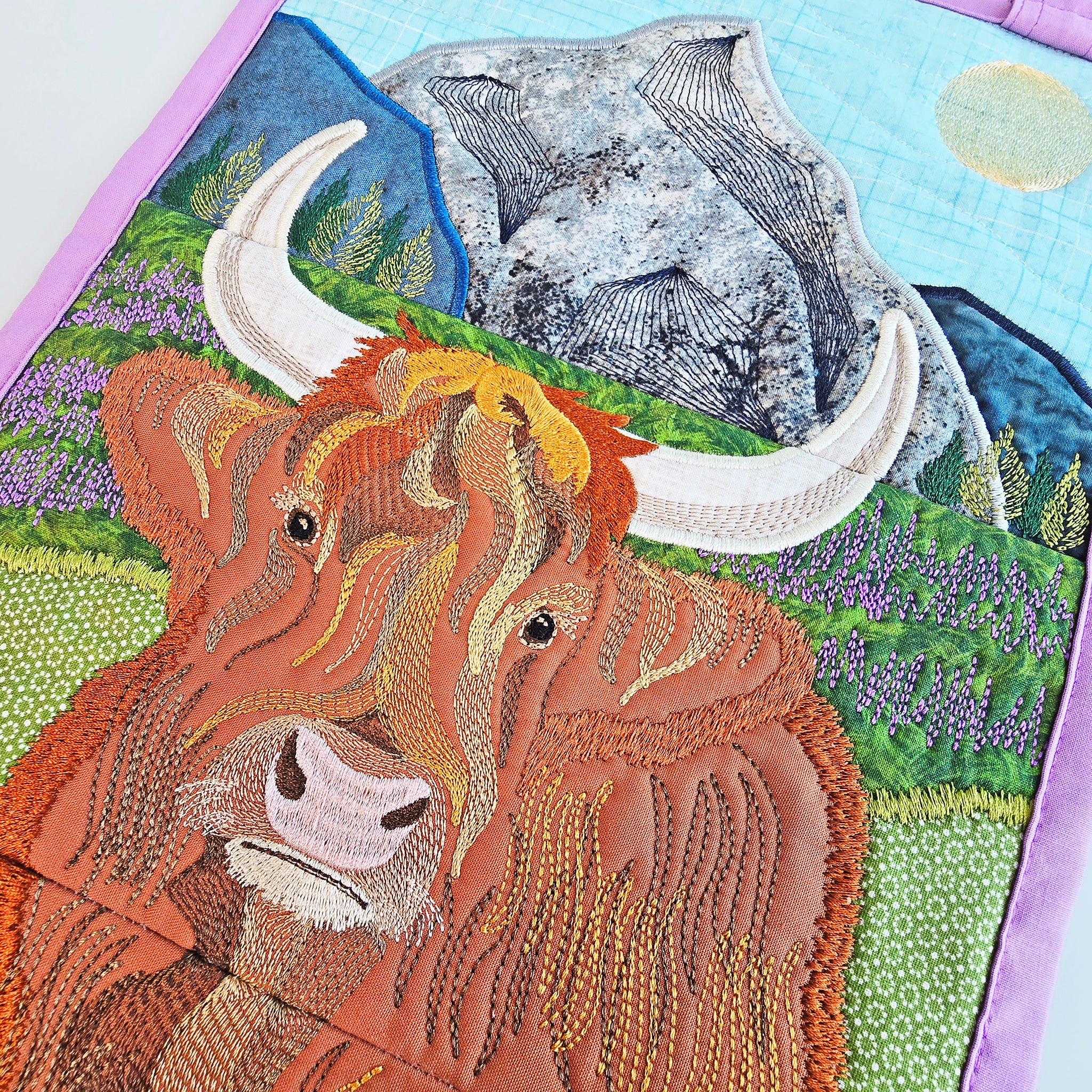 Close-up of a embroidered Highland Cow and Heather