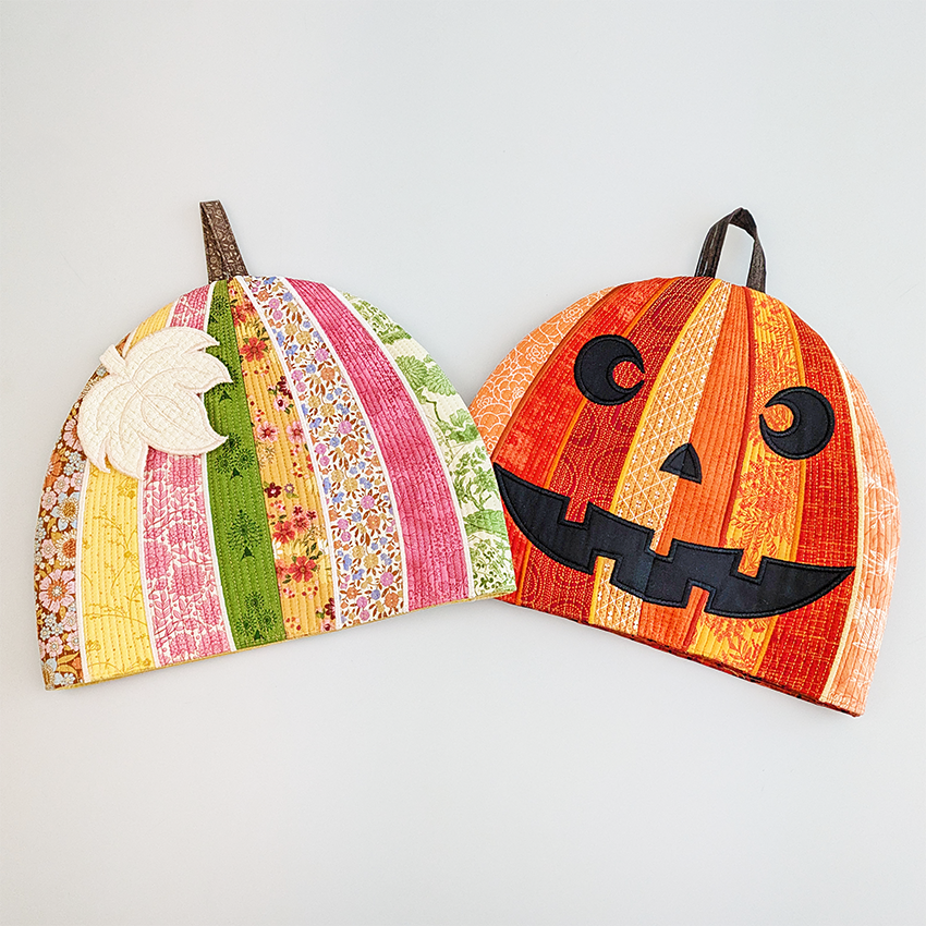 Two decorative pumpkins with one striped pattern and the other with a jack-o'-lantern face by sweet pea